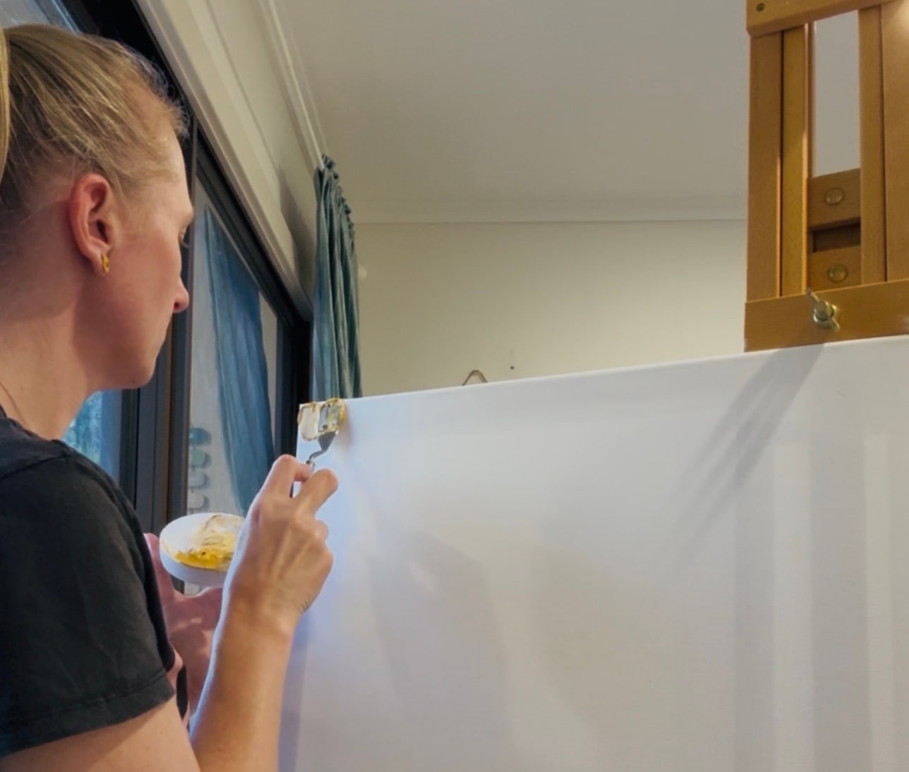 Niki painting a wall-sized canvas at home.